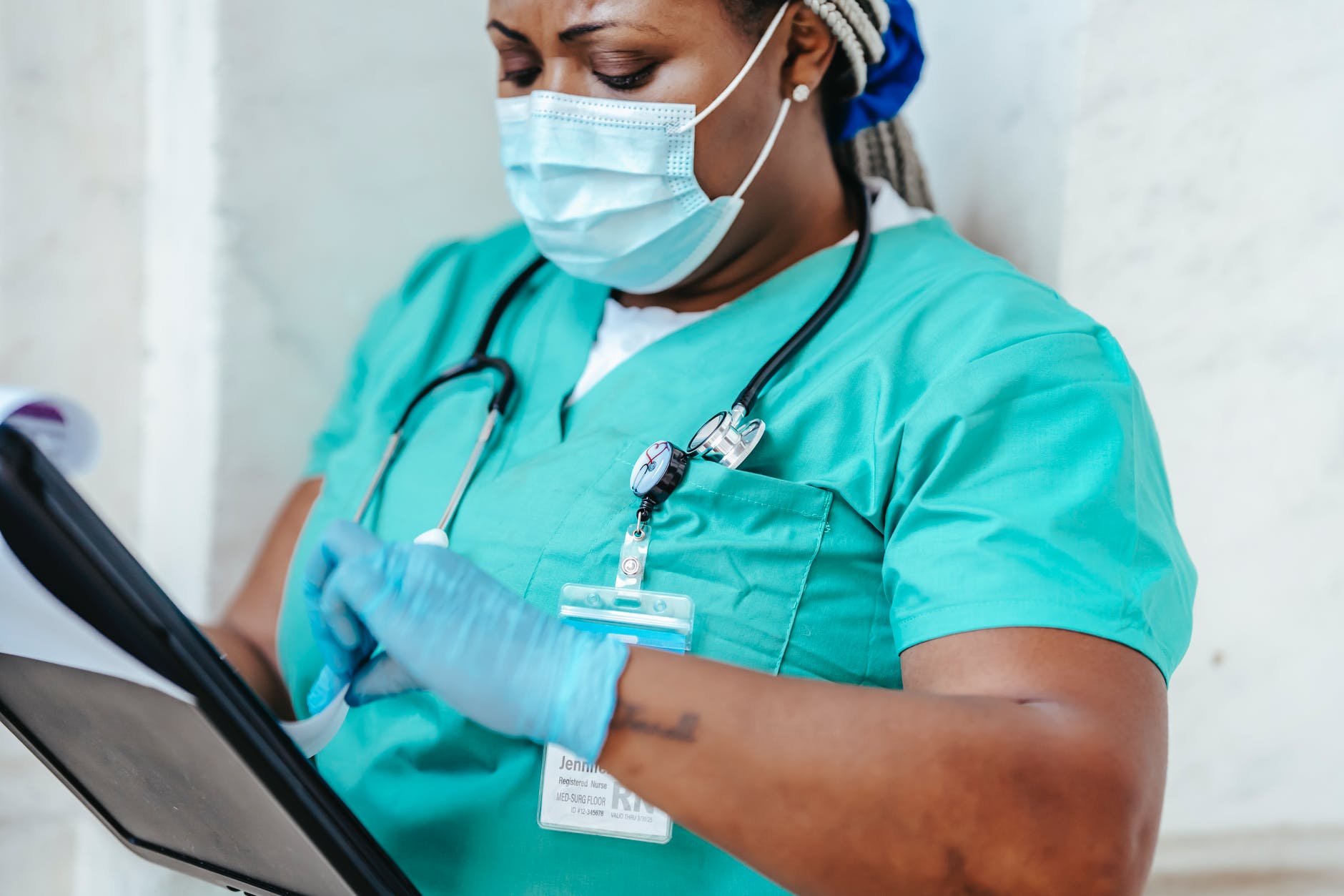 crop nurse in mask and gloves with papers